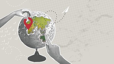 Eine Hand weist auf einen Globus.