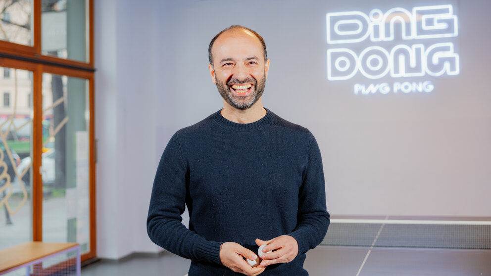 Ding Dong Ping Pong-Mitgründer Kian Pariwar an einer Tischtennisplatte.