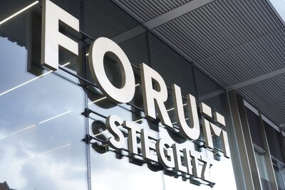 Zu sehen ist der Schriftzug "Forum Steglitz" an der Außenfassade eines Einkaufszentrums im Berliner Stadtteil Steglitz..