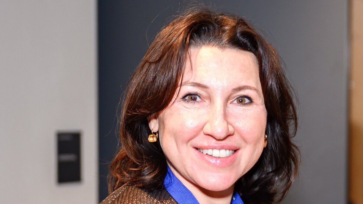 Zu sehen ist eine Frau mit schulterlangen braunen Haaren. Die Frau lächelt freundlich in die Kamera. Es handelt sich um Alla Belikova.