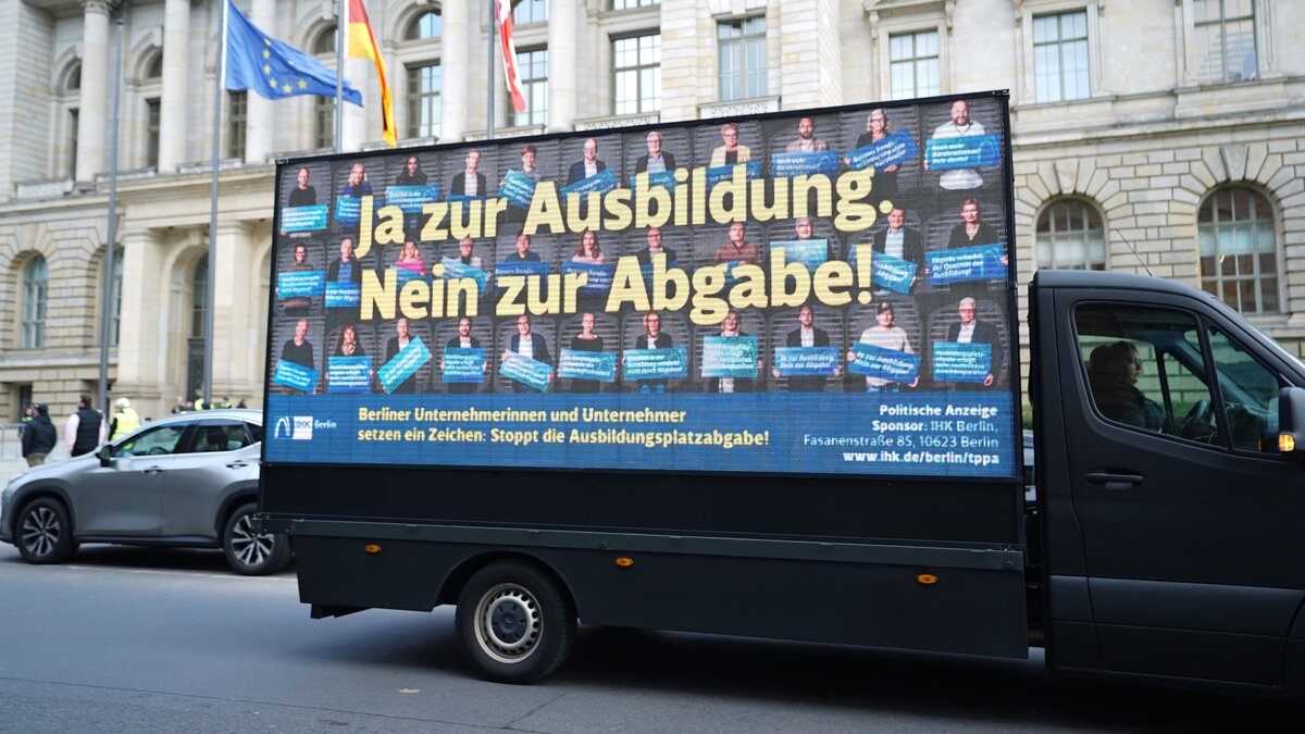 Ein Kleintransporter mit einem Plakat steht vor dem Berliner Abgeordnetenhaus.