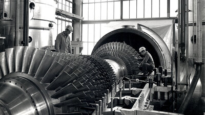Zwei Arbeiter an einer Gasturbine. 