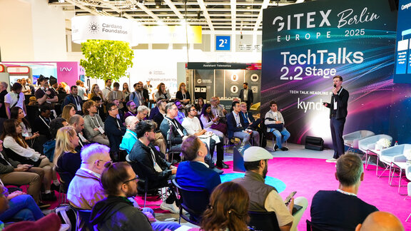 Ein Mann hält an einem Stand auf der Gitex in Berlin einen Vortrag.