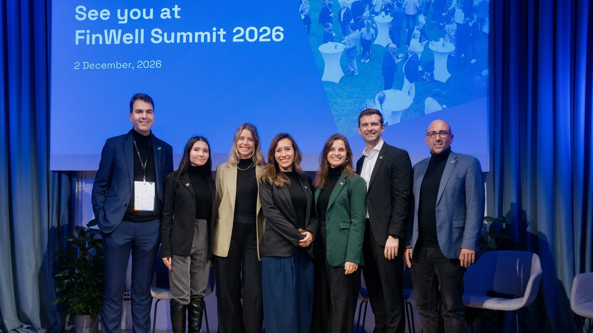 Sechs Personen stehen nebeneinander vor einer blauen Leinwand mit der Aufschrift 'See you at FinWell Summit 2026, 2 December, 2026'.