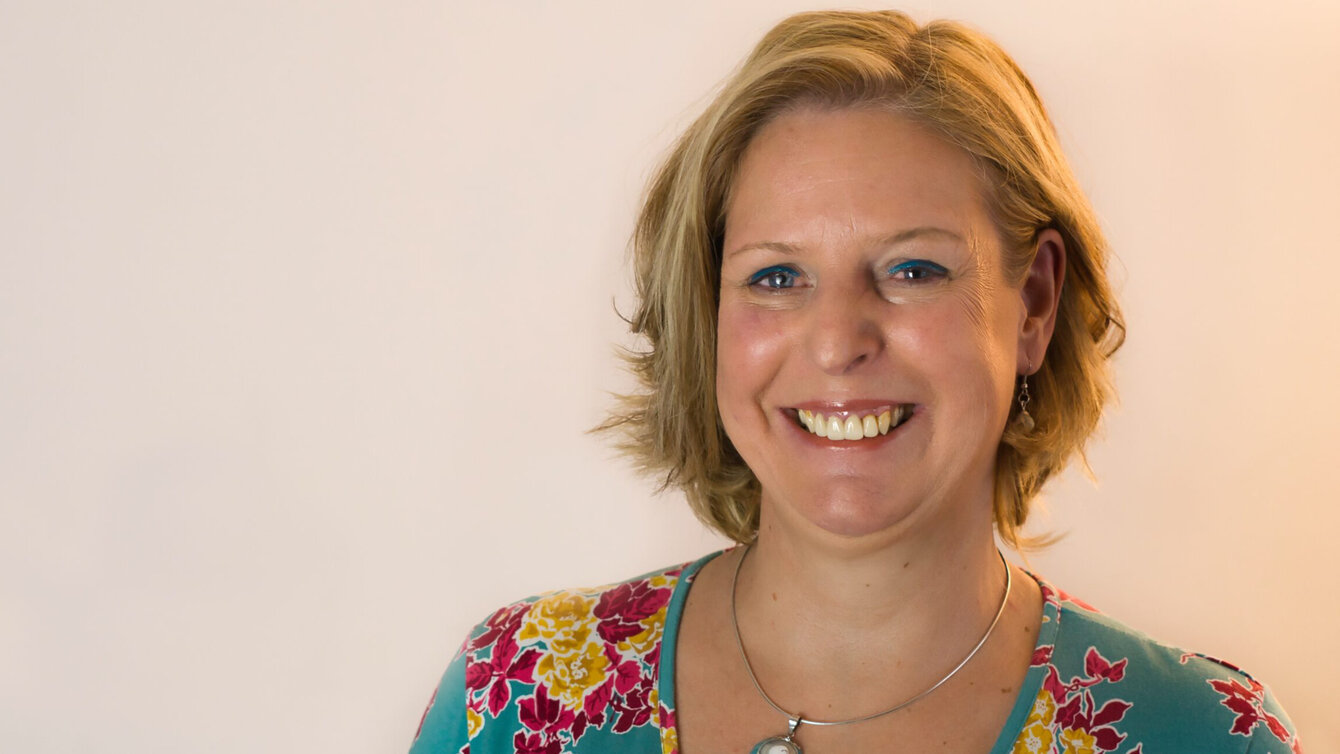 Portraitfoto einer mittelalten Frau mit blonden Haaren.