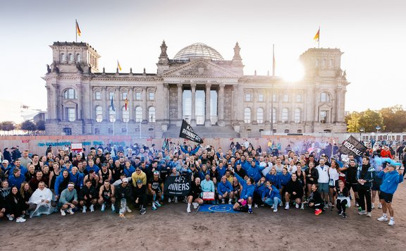 Gruppenbild mit Teilnehmern eines Laufes von KRAFT Runners vor dem Reichstag in Berlin