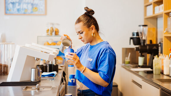 Barista bereitet Kaffee in einer LAP-Filiale zu.