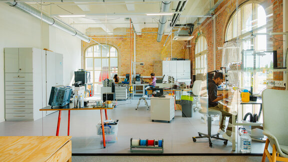 Reflex Aerospace-Mitarbeitende in einem großen, hellen Büro.