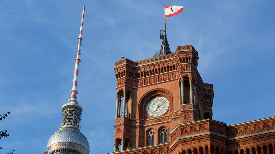 Fernsehturm im Hintergrund vor dem Roten Rathaus mit einer Berlin Flagge