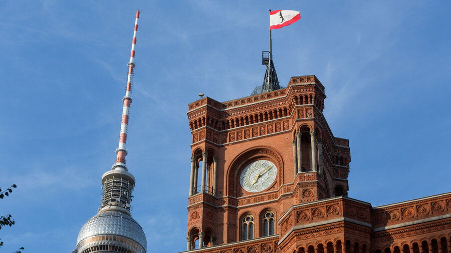 Fernsehturm im Hintergrund vor dem Roten Rathaus mit einer Berlin Flagge