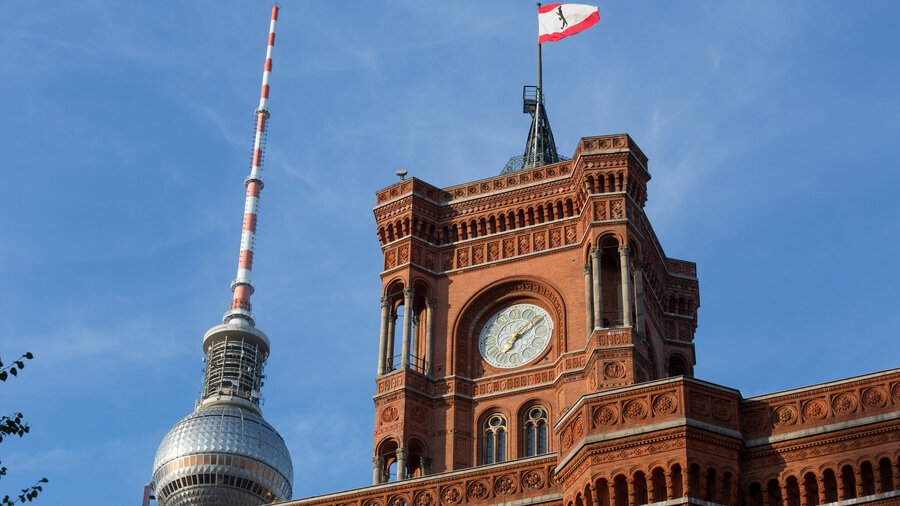 Fernsehturm im Hintergrund vor dem Roten Rathaus mit einer Berlin Flagge