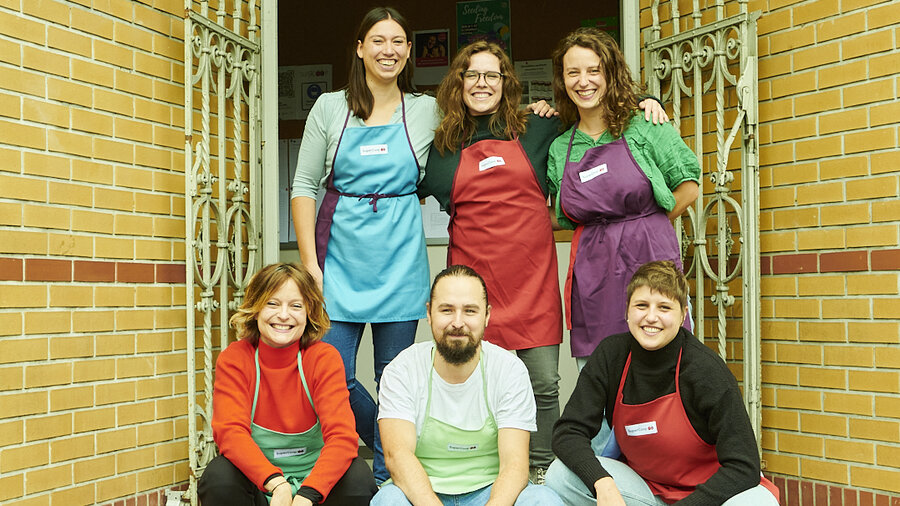 Foto von fünf Mitgliedern von SuperCoop stehen vor einem Türeingang