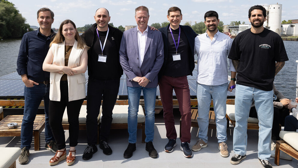 Sieben Menschen posieren freundlich-souverän auf einem Boot – es ist das Management des Berliner Fintechs Vivid.