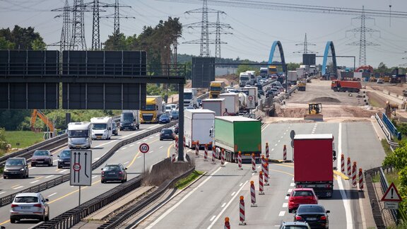 Zu sehen ist eine befahrene Autobahn. Auf einer Spur befindet sich eine Baustelle, weswegen eine Fahrbahn geteilt wurde, dort fahren die Fahrzeuge in beide Richtungen.