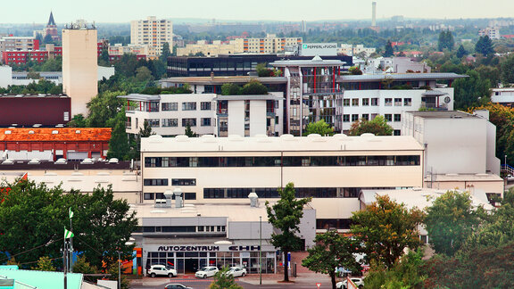 Blick auf mehrstöckige Büro- und Wohngebäude in einer Stadt mit Bäumen und Straßen im Vordergrund