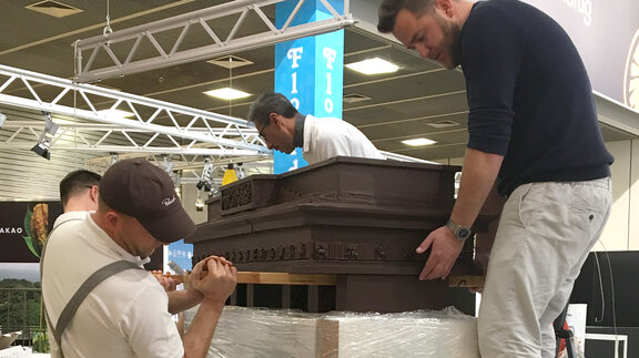 Handwerker montieren ein Gebäude aus Schokolade 