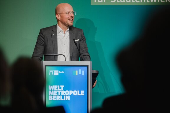 IHK-Präsident Sebastian Stietzel hält an einem Pult auf einer Bühne eine Rede.