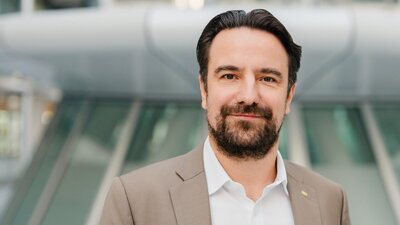 Zu sehen ist ein mittelalter Mann, der feundlich in die Kamera schaut. Es handelt sich um den Vizepräsidenten der IHK Berlin Robert Rückel.