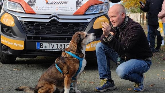 Sebastian Hövel gibt einem Hund ein Leckerli. 