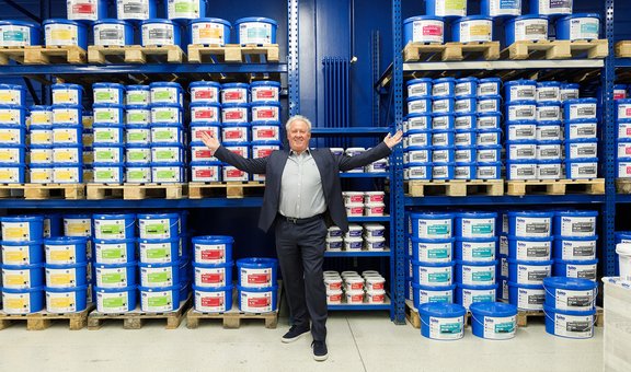 Joachim Spitzley, Vorstandsvorsitzender der Bito AG, steht vor einer Wand mit Farbeimern