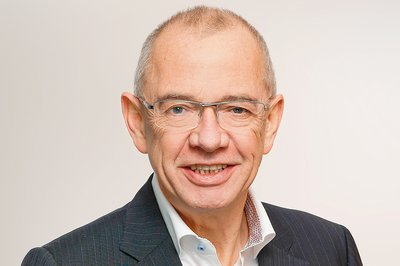 Ein Mann in einem Anzug lächelt in die Kamera.