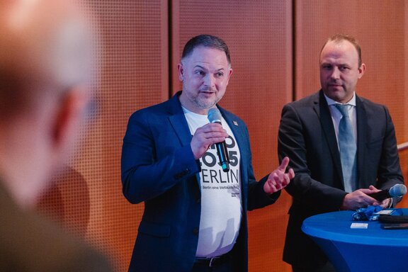 Ein Mitarbeiter der Expo 2025 spricht in ein Mikrofon.