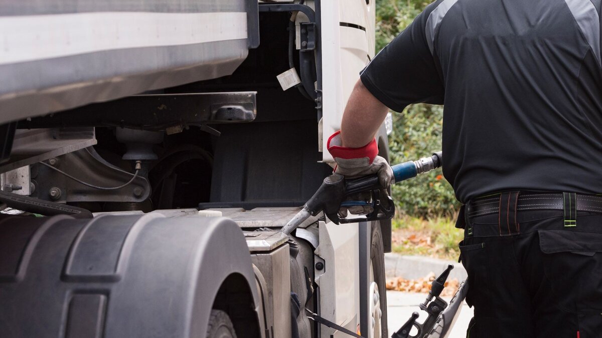 Zu sehen ist ein Mann, welcher einen Lkw betankt.