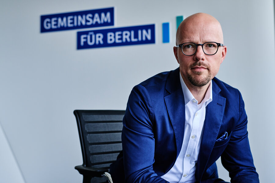 IHK-Präsident Sebastian Stietzel sitzt vor einer blauen Rückwand mit dem Schriftzug Gemeinsam für Berlin 