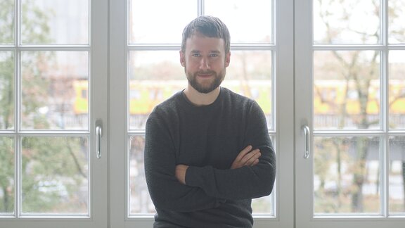 Christoph Lange von Idagio steht vor einem Fenster.