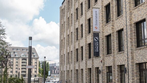  Eine Fahne mit der Aufschrift „Solarisbank“ an einem modernen Gebäude in Berlin-Kreuzberg