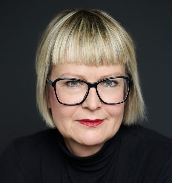 Zu sehen ist eine blonde Frau mit Brille, es ist Stephanie Salziger, Center Managerin von LIVING BERLIN