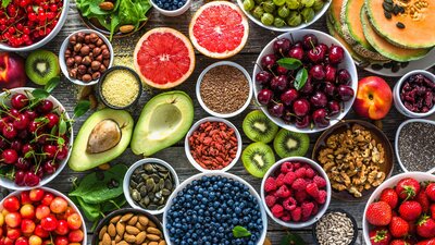 Zu sehen ist ein Tisch, auf dem zahllose Schalen mit Beeren, aufgeschnittenes Obst und Avocados liegen.