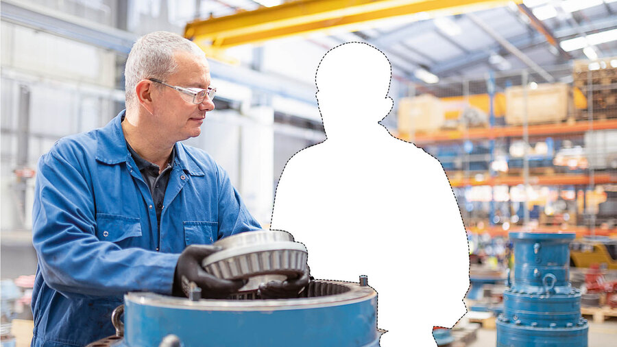Foto von zwei Personen in einer Werkstatt. Eine der beiden Personen ist aus dem Bild geschnitten.