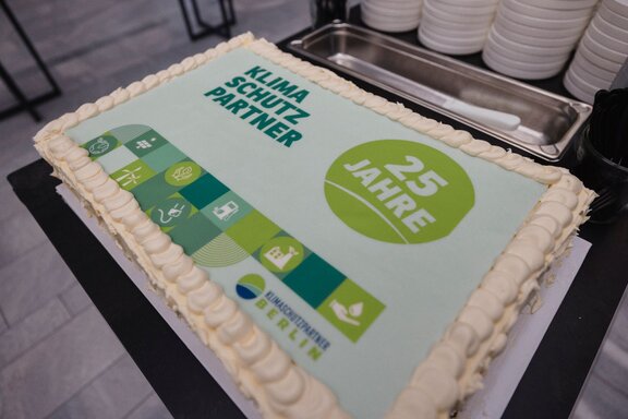 Zu sehen ist eine rechteckige Torte mit Motiv. Auf der Torte Steht Klimaschutzpartner - 25 Jahre.