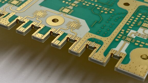 Nachaufnahme von einer Leiterplatte mit goldenen und grünen Elementen.  
