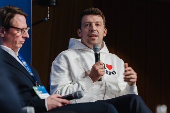 Expo-2035-Initiator Daniel-Jan Girl spricht in ein Mikrofon.