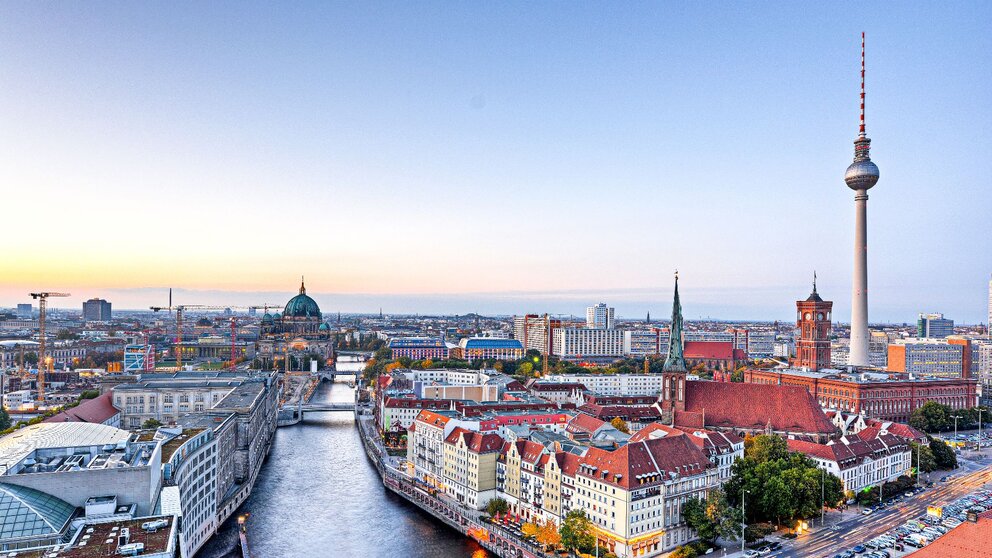 Man blickt aus der Vogelperspektive auf Berlin. Man sieht das Zentrum mit dem Fernsehturm und dem Roten Rathaus sowie die Spree.