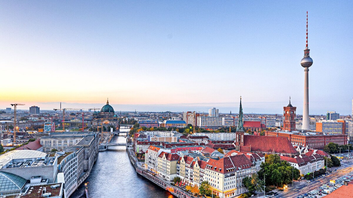 Man blickt aus der Vogelperspektive auf Berlin. Man sieht das Zentrum mit dem Fernsehturm und dem Roten Rathaus sowie die Spree.