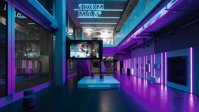 Zu sehen ist ein neon-lila-beleuchtetes Bürogebäude. Es handelt sich um das TechLab Berlin der Firma 1Komma5°.
