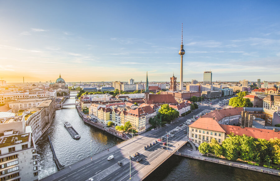 Zu sehen ist eine Großstadt von oben, durch die ein Fluss fließt. Es handelt sich um Berlin und die Spree.