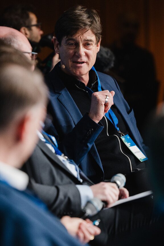 Ein Mann spricht zu Diskussionspartnern.