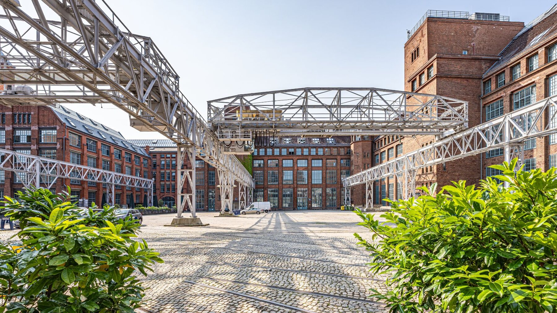 Zu sehen ist eine Gewerbehof, dessen Häuser aus rotem Backstein bestehen. Es handelt sich um den Gewerbehof Amperium am Humboldthain in Berlin mitte.