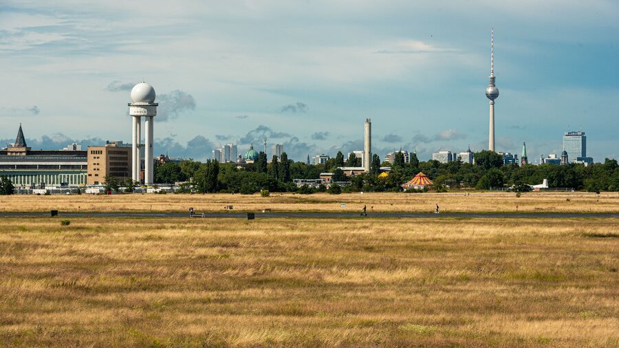 zu sehen ist eine weite Wiese, im Hintergrund der Fernsehturm von Berlin. Es handelt sich um das Tempelhofer Feld.