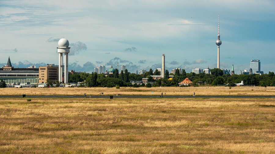 zu sehen ist eine weite Wiese, im Hintergrund der Fernsehturm von Berlin. Es handelt sich um das Tempelhofer Feld.