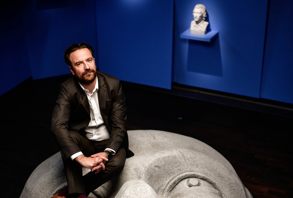 Ein Mann sitzt auf dem Kopf eines Museumsexponats.