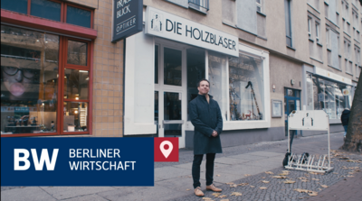 Mann steht vor einem Geschäft auf dem Gehweg in Berlin
