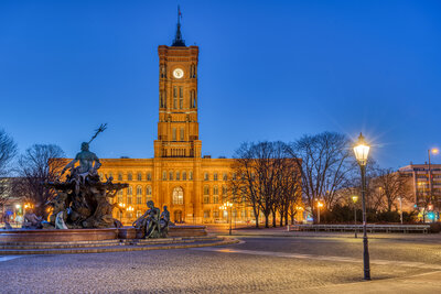 Zu sehen ist ein angestrahltes großes Gebäude bei Nacht. Es ist das Rote Rathaus in Berlin.
