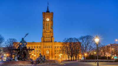 Zu sehen ist ein angestrahltes großes Gebäude bei Nacht. Es ist das Rote Rathaus in Berlin.