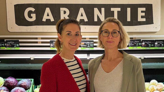 Zwei Frauen schauen freundlich in die Kamera, im Hintergrund ist ein Gemüseregal im Supermarkt, es sind Daniela Feldt und Nicole Korset-Ristic,  Vorständinnen der Bio Company