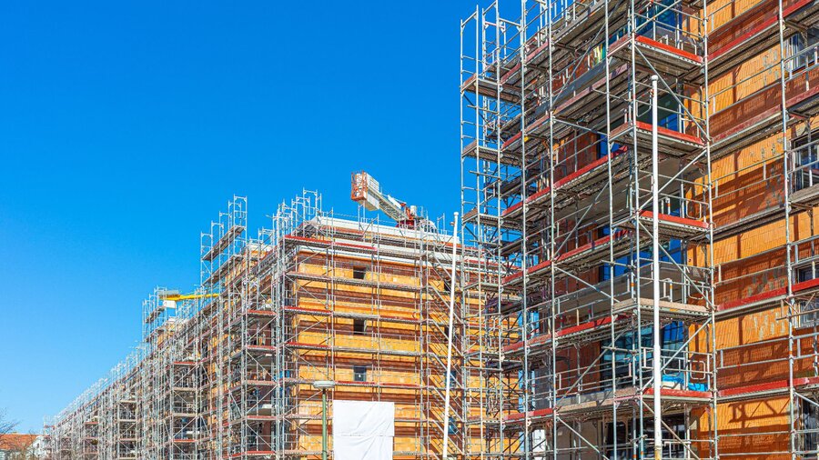 Zu sehen sind zwei Mehrfamilienhäuser mit Baugerüst. Man sieht eine Wohnungsbaustelle.